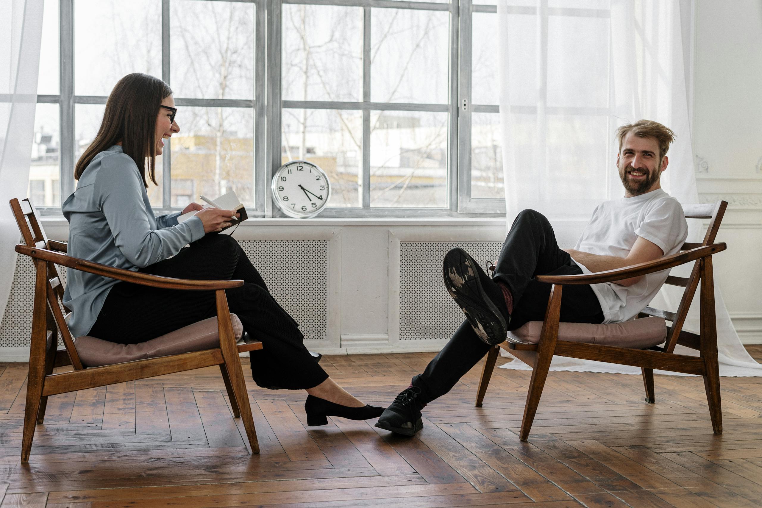 Two professionals engaged in a consultation, one taking notes on a clipboard.