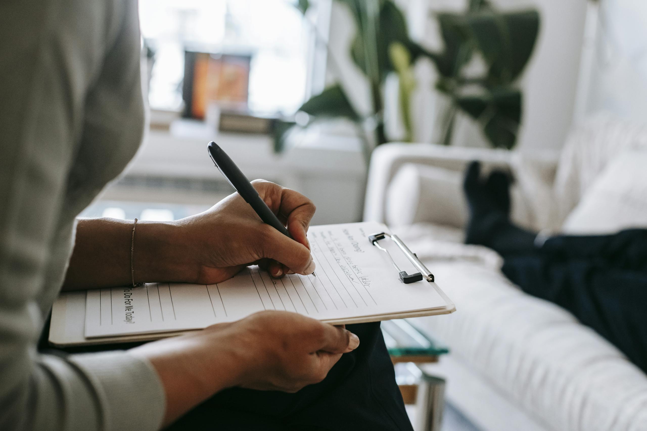 A therapist consults with a client in a contemporary office, focusing on mental health.